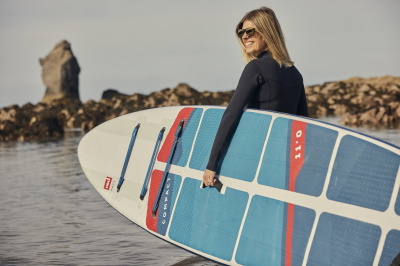 Paddle boarder on flat water wearing a buoyancy aid