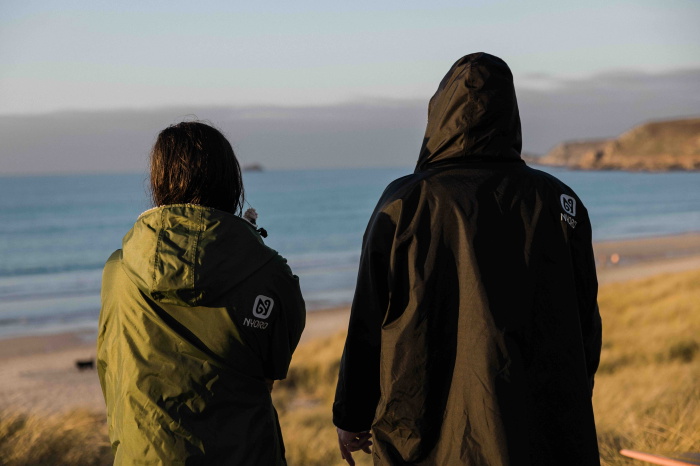 Cold-water swimmer wrapped in a waterproof fleece-lined change robe on a winter beach