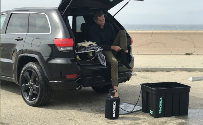 Man in his car next to a beach box shower