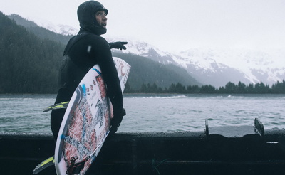 Surfer wearing wetsuit boots, gloves and a hood